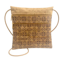A cork bag with two front zippered pockets and an adjustable crossbody cork strap. The front of the bag has a wine colored traditional tile pattern. 