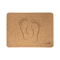 A natural cork bath mat with a set of footprints reminiscent of stepping out of a pool.