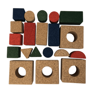 The cork blocks laid out showing squares with holes for pegs, semi circles, rectangles, squares and pegs in a mixture of natural, red, blue and green colors.