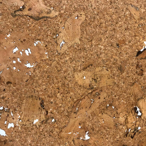 A close up view of the natural cork paper contains variations in the natural brown color with thinner places and a few holes.