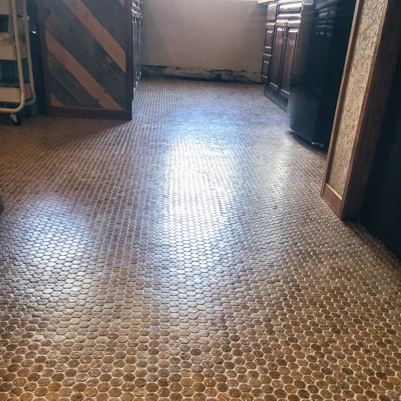 A kitchen floor made of cork penny tiles with a high gloss finish.
