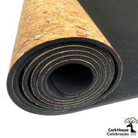 A side view of a partially rolled cork and natural rubber yoga mat highlighting the thickness of the mat and the colorful confetti pattern on the cork top. 