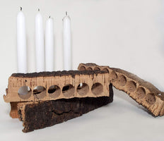 These four cork bark punches feature the dark outer bark with the signature lighter cork "meat." One of the cork bark punches is holding four white table candles.