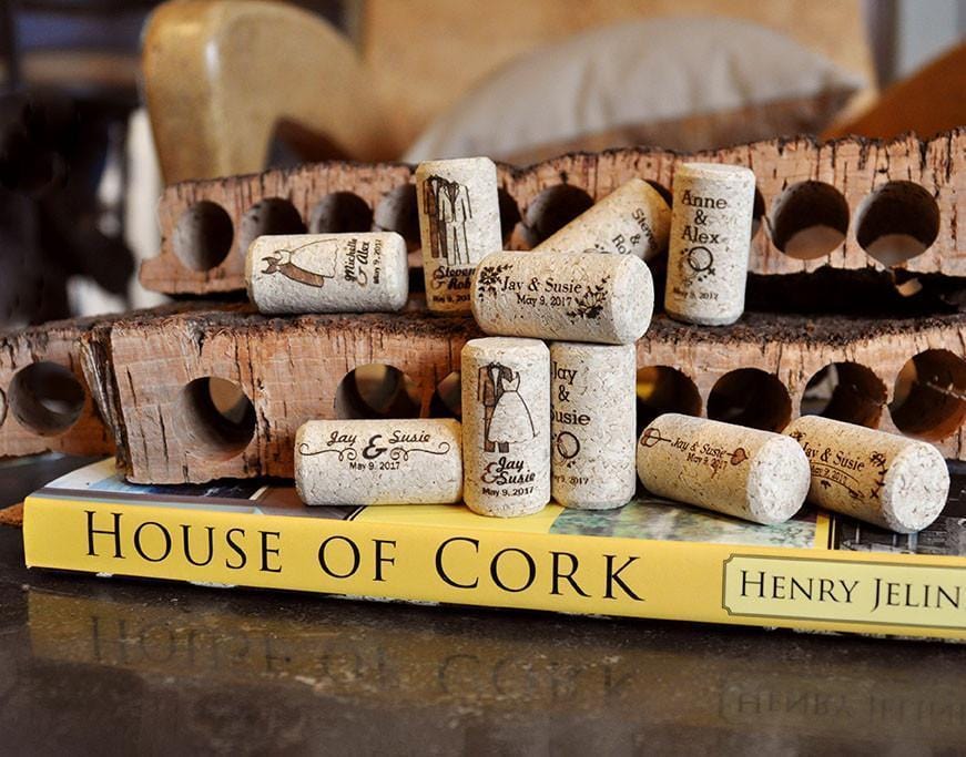 A selection of wedding themed custom printed wine corks on a house of cork book with cork bark punches in the background.